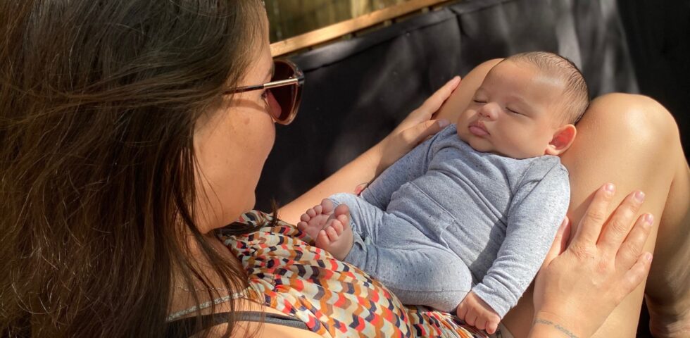 Lisette Liefting zit op de bank met baby Nio op schoot.
